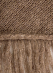 Close-up of a brown knitted fabric with fringes