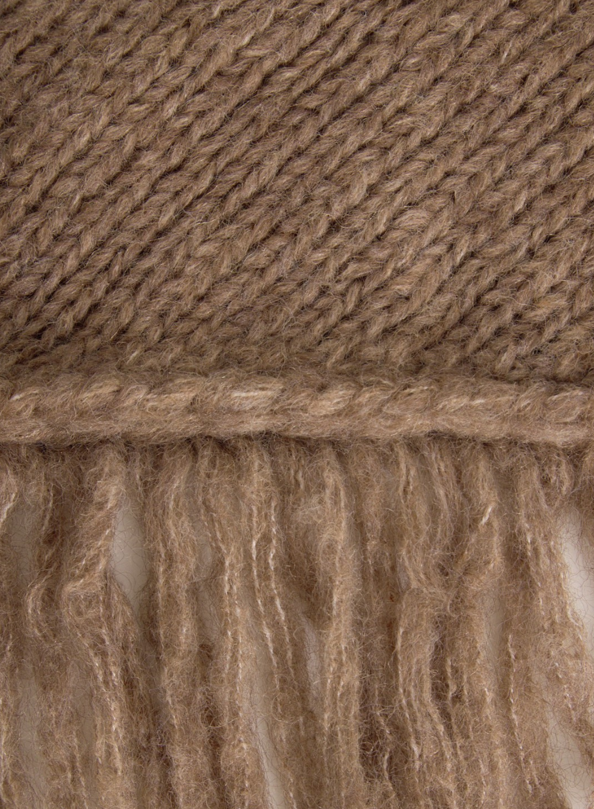Close-up of a brown knitted fabric with fringes
