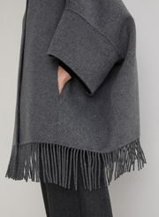 Gray poncho with fringes on a plain background