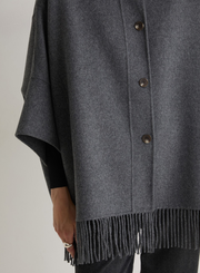 Gray poncho with fringes and buttons on a neutral background
