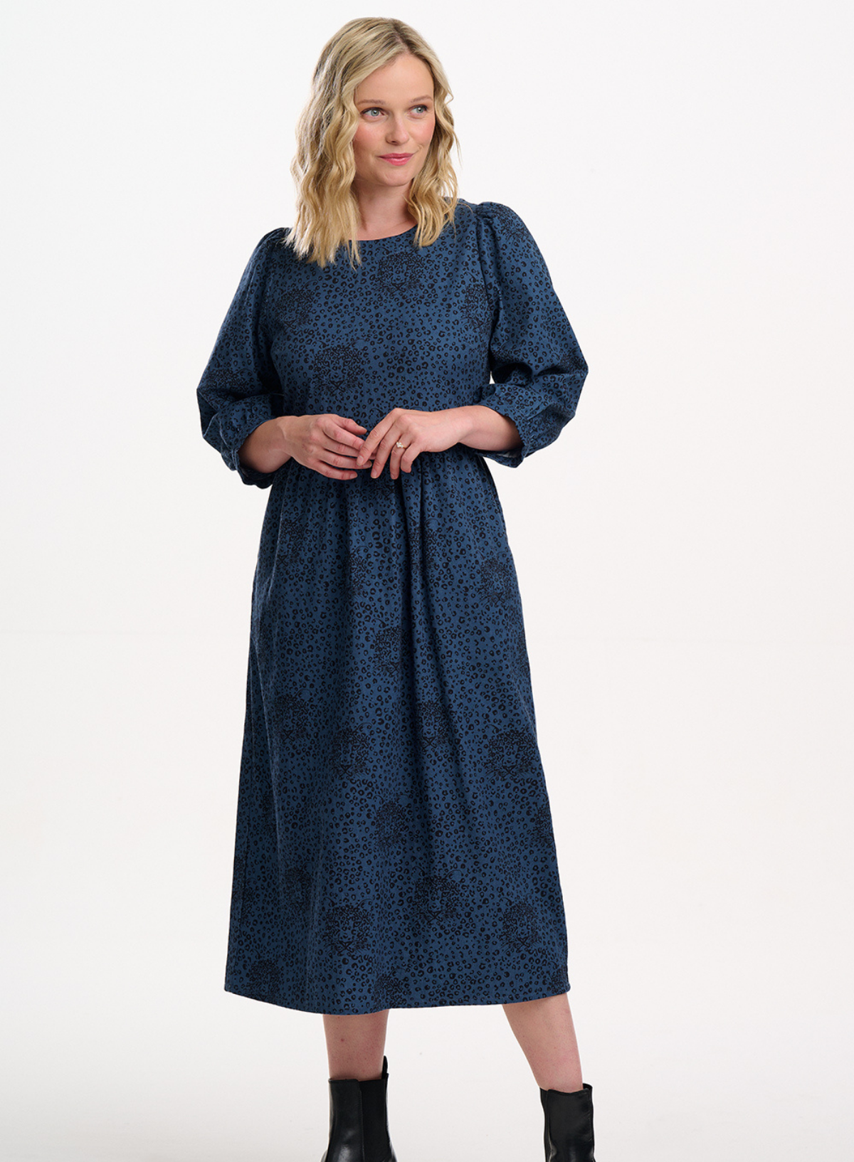 Woman wearing a blue patterned dress on a white background