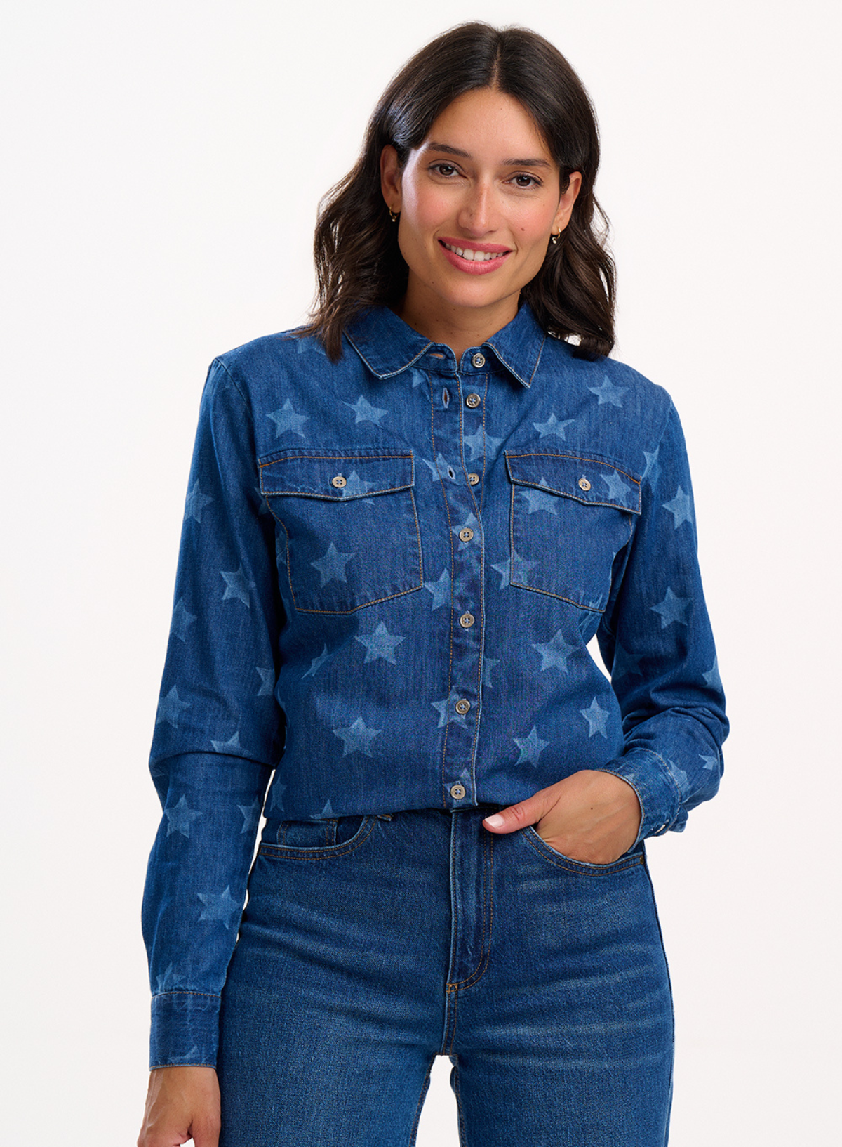 Woman wearing a blue denim shirt with star patterns on a white background