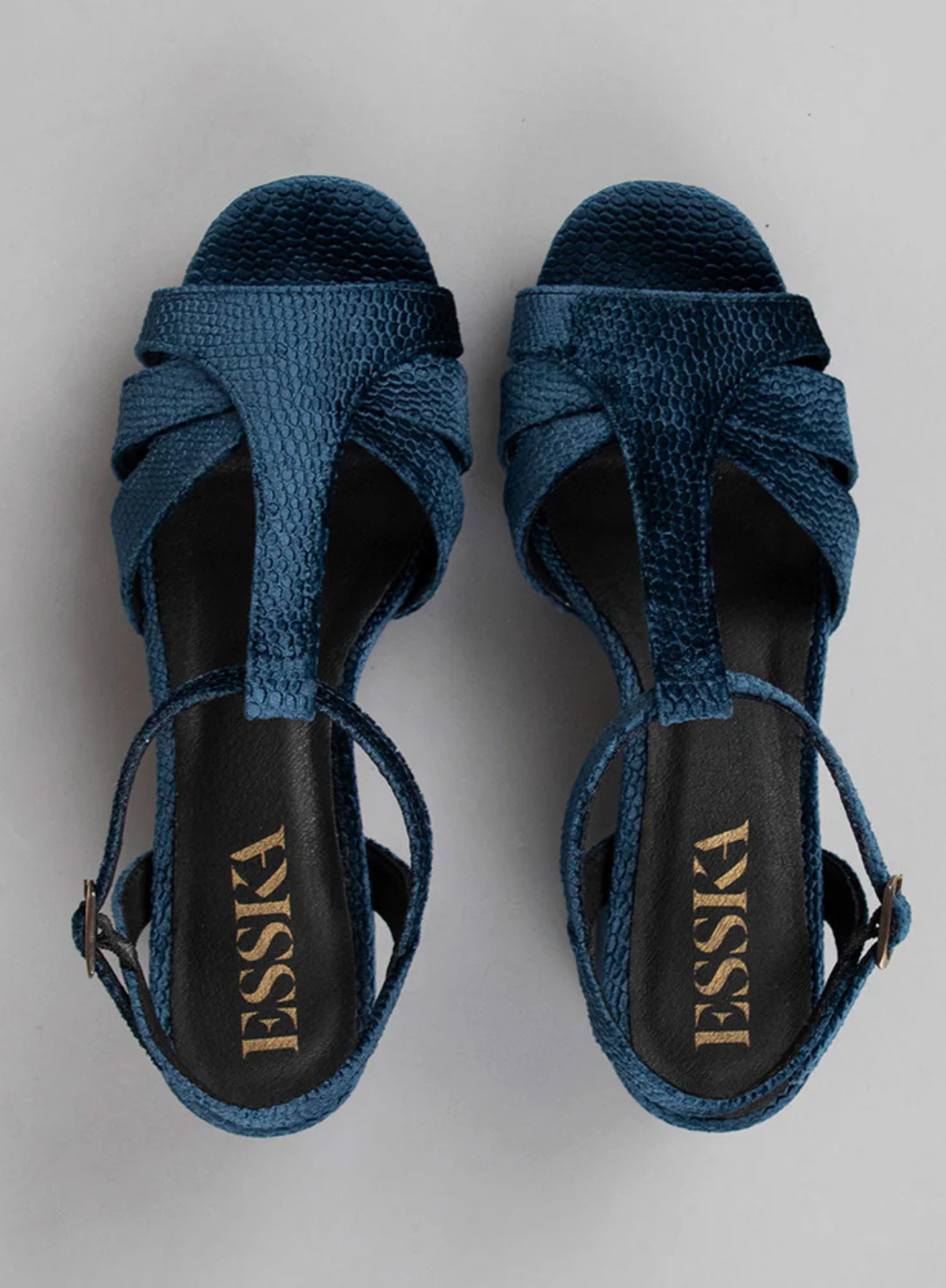 Pair of Esska Charlie Blue Velvet T Bar Heels on a grey background. Overhead shot showcasing the embossed velvet detail and the t bar straps of these block heel sandals.