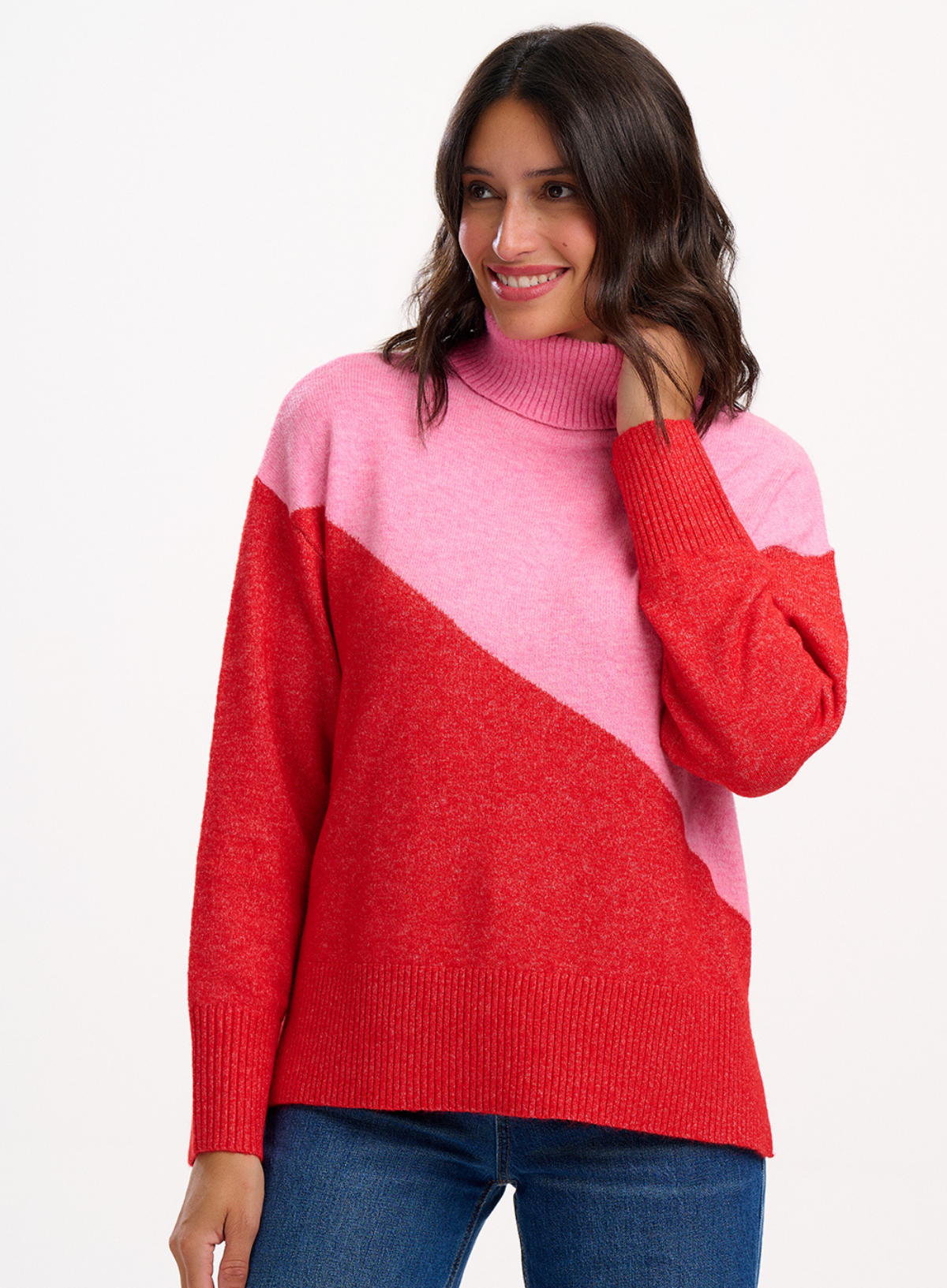 Woman wearing the Sugarhill Brighton Winona Pink Red Colour Block Roll Neck Jumper on a white background