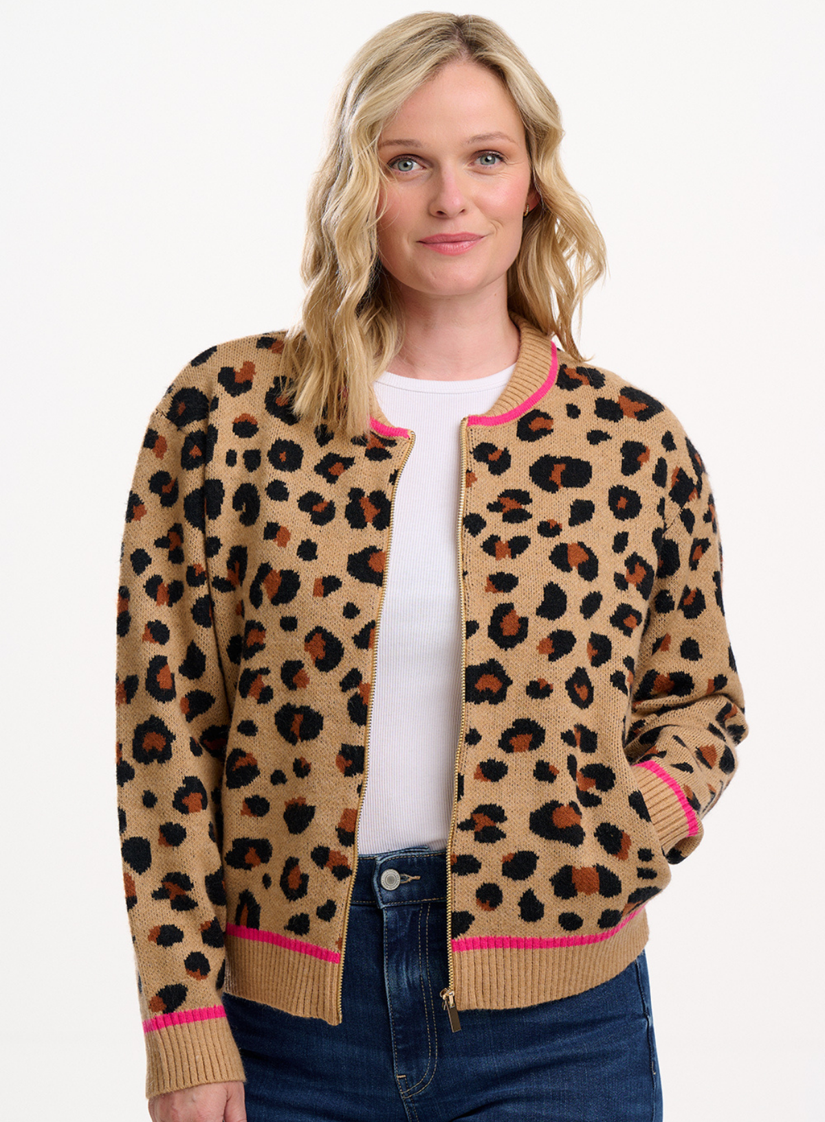 Woman wearing a leopard print cardigan with pink trim on a white background