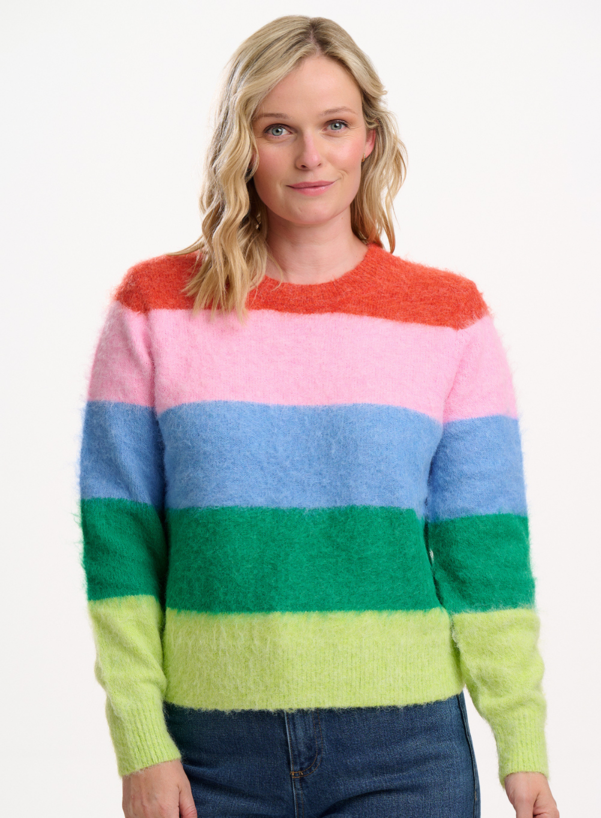 Woman wearing a colourful Sugarhill Brighton striped jumper on a white background