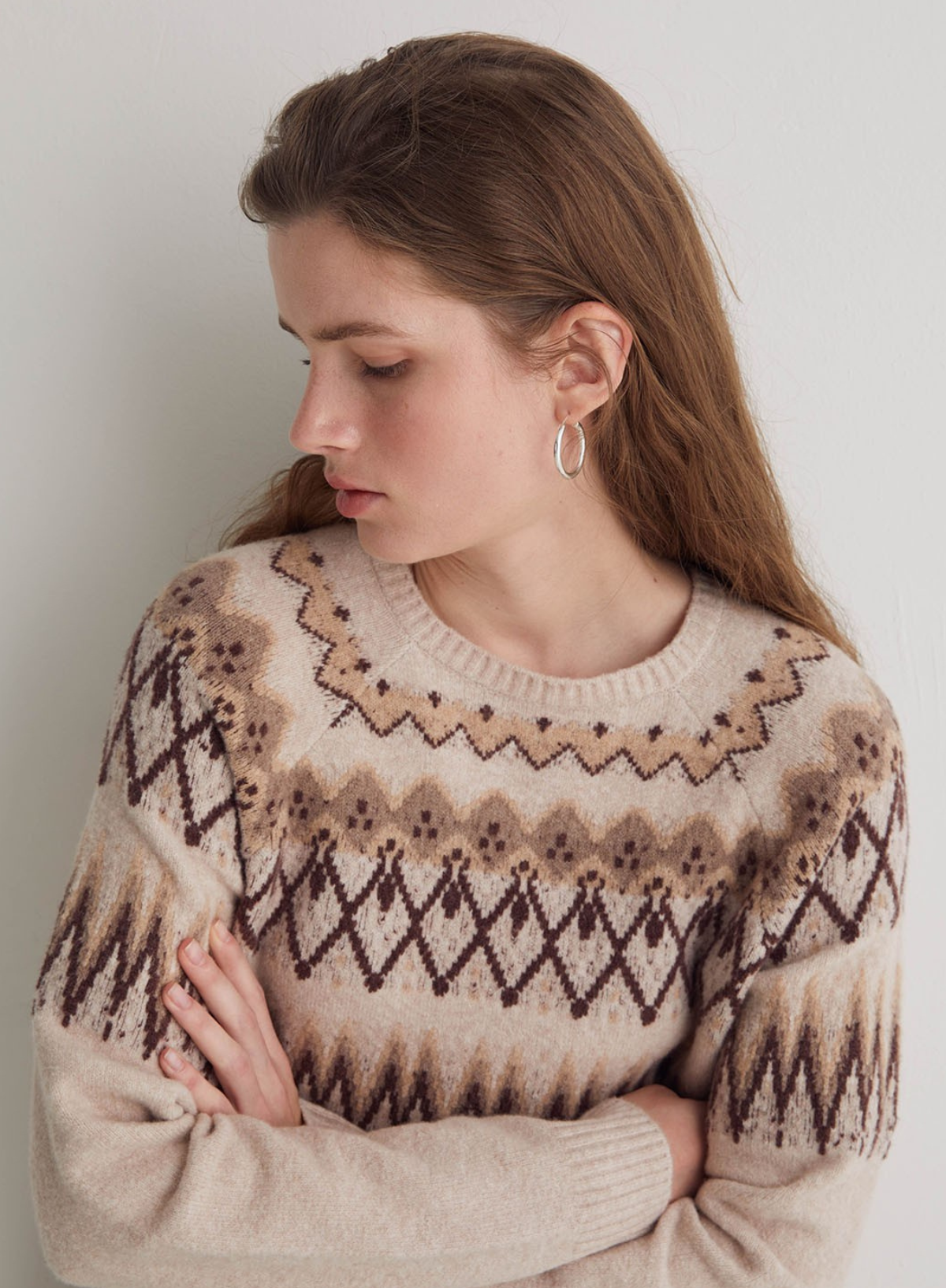 Woman wearing a patterned sweater against a plain background