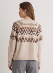 Woman wearing a patterned sweater on a plain background